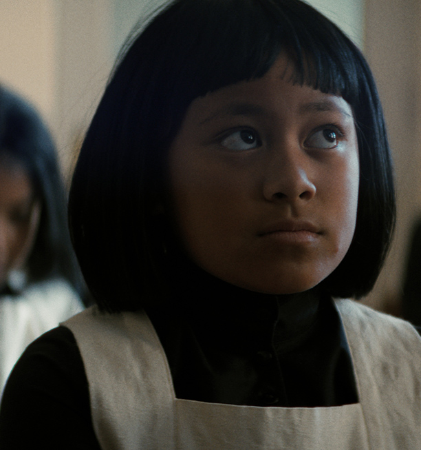 Native girl in bob haircut in Native Boarding school attire.