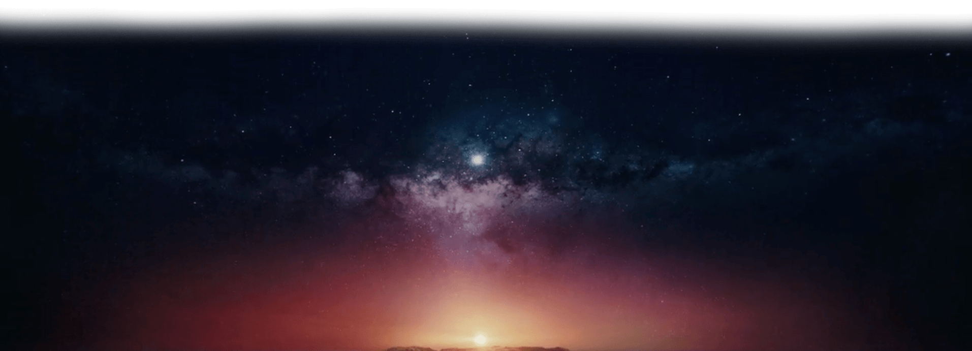The Milky Way across a starry night sky above a sun glowing on the horizon.